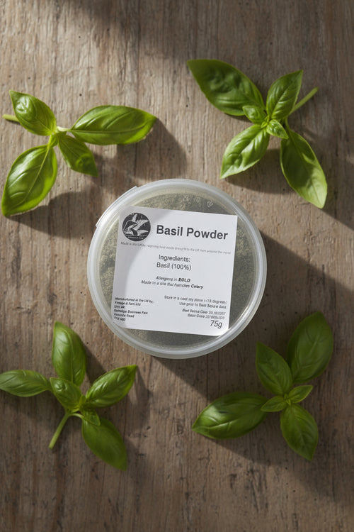 Container of basil powder with a label on a rustic background