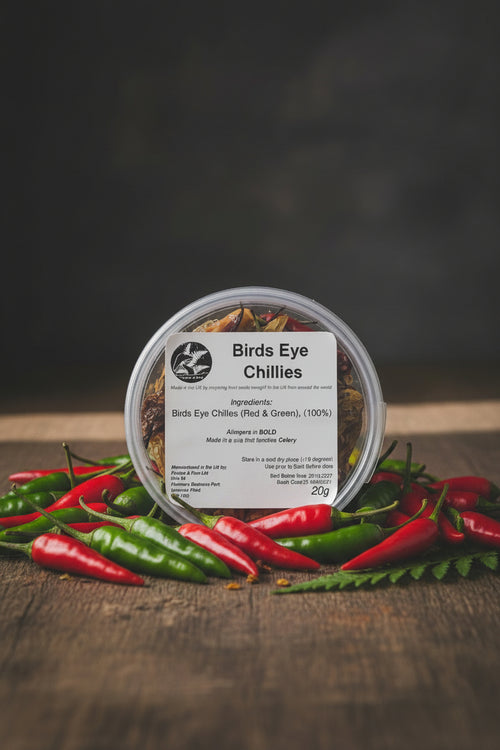 Container of Birds Eye chilies with a label on a rustic background