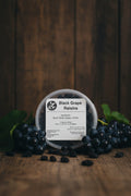 Pot of black grape raisins with a label on a rustic background