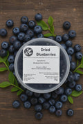 Container of dried blueberries with a label on a rustic background
