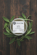 Container of ground sage with a label on a rustic background