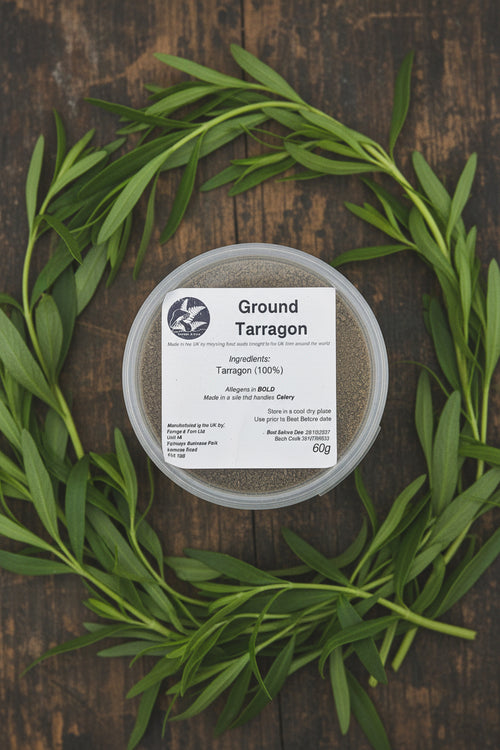 Container of ground tarragon with a label on a rustic background